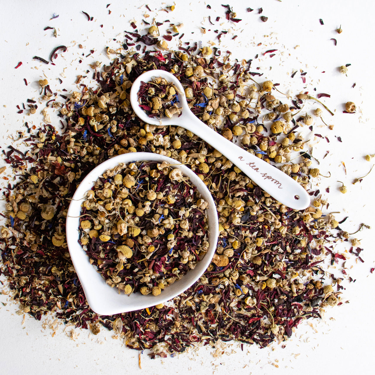 Scene of tea sprinked in and around a bowl and teaspoon.