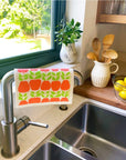 Apples Swedish Dishcloth draped on sink faucet